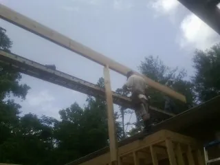 Carpenter setting a ridge beam over a new addition frame — Ice Dam Removal by Roofing Brothers in Mooresboro