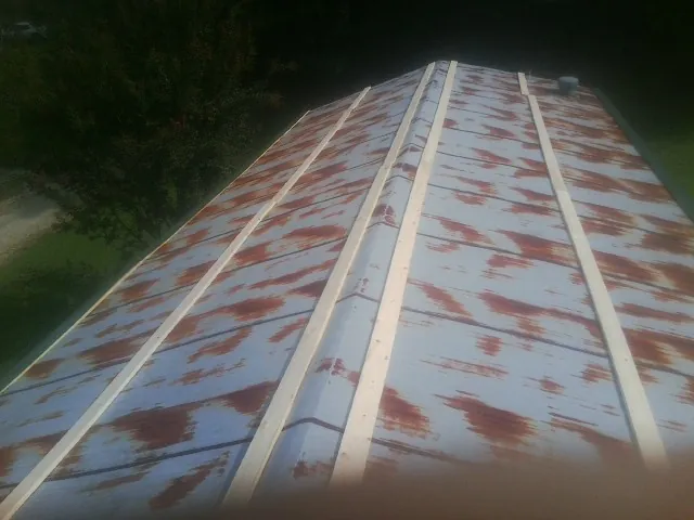 Rusted metal roof panels with new wood purlins before replacement — Storm Damage Roof Repair in Mooresboro by Roofing Brothers