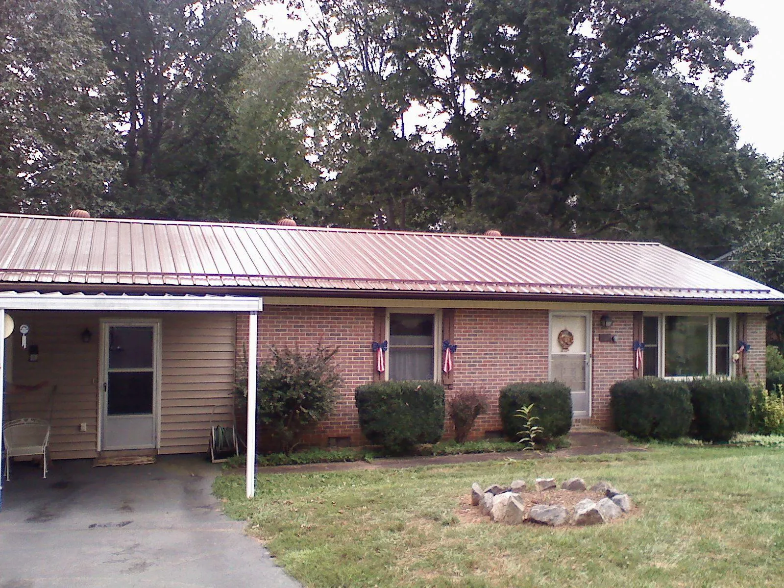 Bronze metal roof and carport on a brick ranch home — Roof Repair work by our crew in Mooresboro
